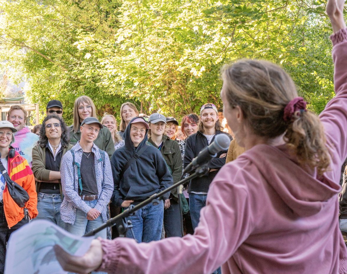 Sophie doing a silly pose viewed from behind, performing to a grinnning audience